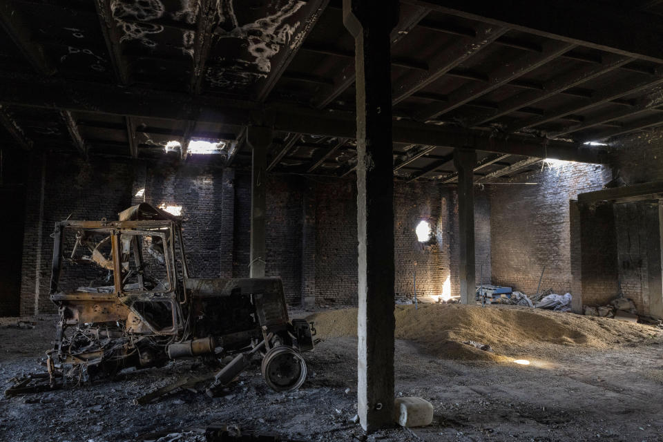 FILE - A tractor charred by a Russian attack lies inside a warehouse at a grain farm in Cherkaska Lozova, outskirts of Kharkiv, eastern Ukraine, Saturday, May 28, 2022. Russian hostilities in Ukraine are preventing grain from leaving the "breadbasket of the world" and making food more expensive across the globe, raising the specter of shortages, hunger and political instability in developing countries. As food costs and fuel bills soar, inflation is plundering people’s wallets, sparking a wave of protests and workers’ strikes around the world. (AP Photo/Bernat Armangue, File)