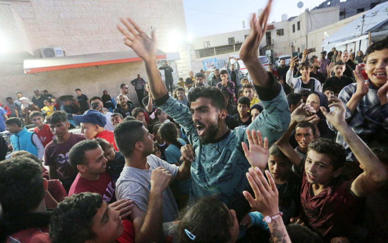 Palestinians gather outside the Al-Aqsa Martyrs Hospital in Deir al-Balah
