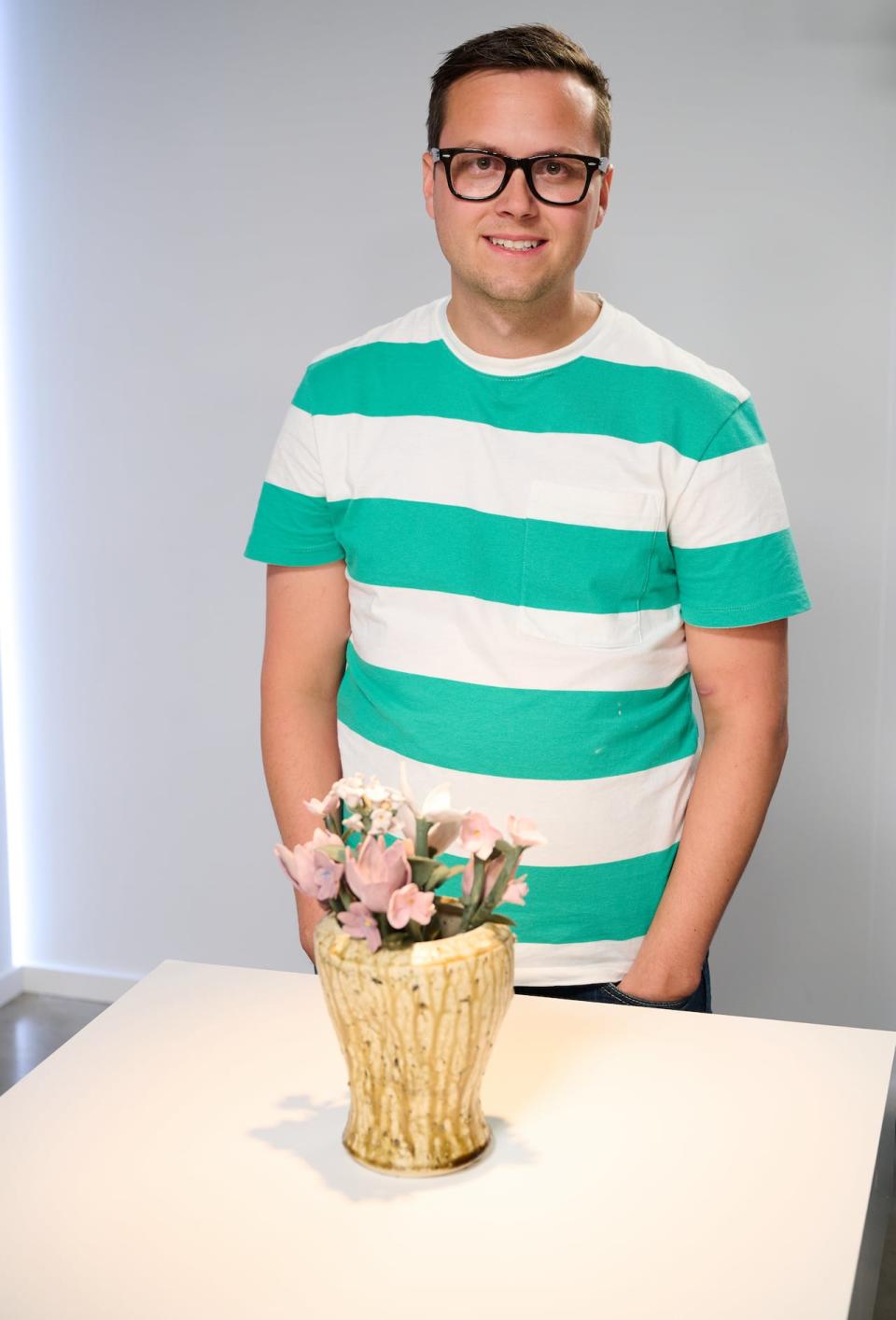 Michael Wood presents the ceramic vase and flowers he created during the CBC reality show competition The Great Canadian Pottery Throw Down, as part of a challenge on the theme of a hometown tribute. His clay included crushed up rocks from his driveway. 