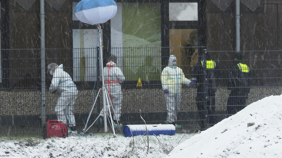 Investigators and forensic experts stand outside a Jehovah's Witness building in Hamburg, Germany Friday, March 10, 2023. Shots were fired inside the building used by Jehovah's Witnesses in the northern German city of Hamburg on Thursday evening, with multiple people killed and wounded, police said. (Steven Hutchings/Tnn/dpa via AP)