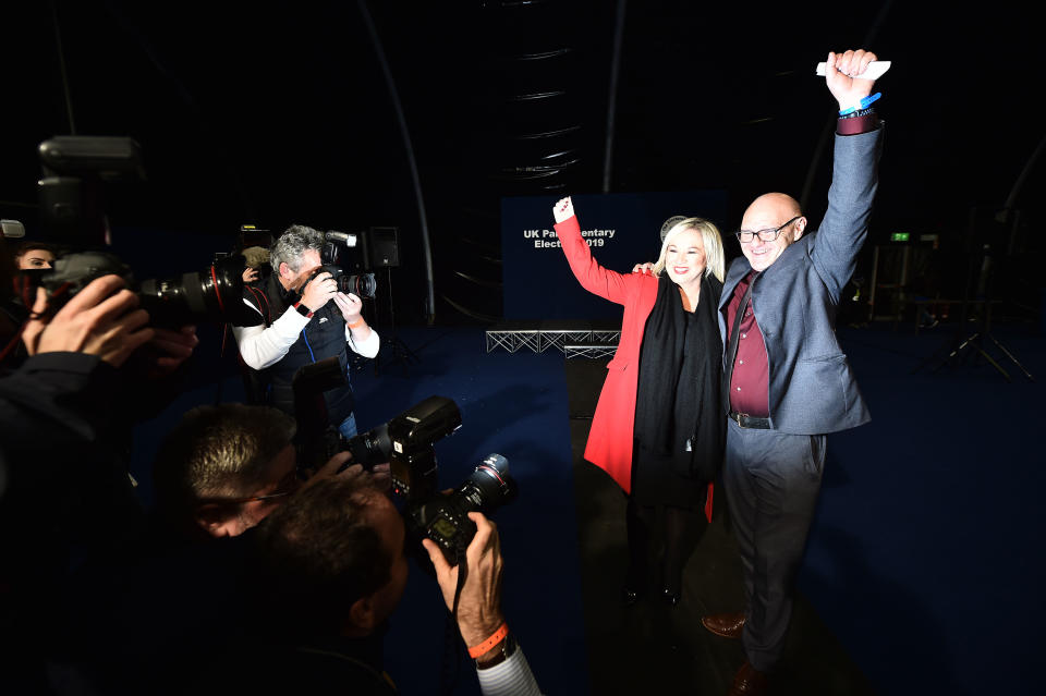 BELFAST, NORTHERN IRELAND - DECEMBER 13:  Sinn Fein candidate Paul Maskey celebrates his victory in the west Belfast constituency alongside Sinn Fein northern leader Michelle ONeill in the Belfast count centre at the Titanic Exhibition centre on December 13, 2019 in Belfast, United Kingdom. The current Conservative Prime Minister Boris Johnson called the first UK winter election for nearly a century in an attempt to gain a working majority to break the parliamentary deadlock over Brexit. The election results from across the country are being counted and an overall result is expected in the early hours of Friday morning. (Photo by Charles McQuillan/Getty Images)