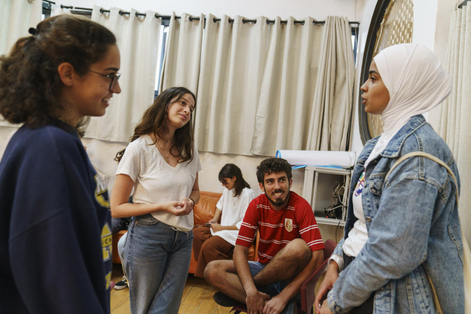 Jewish participants in a youth program that brings Arabs and Jews together, from left, Shay-Lee Vashaly, 19, Leeor Oz, 18, and Gal Benovich, 18, talk with their Arab counterpart Khadeeja Abu Ghanim, 19, right, for the first time since violent clashes between Jews and Arabs broke out in the mixed Arab-Jewish town of Lod, central Israel, Monday, May 31, 2021. (AP Photo/David Goldman)