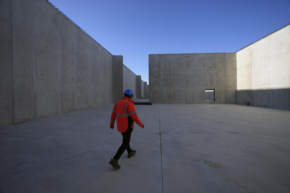 Thierry Pochot, spokesperson for radioactive waste storage sites in the Aube region of eastern France managed by French radioactive waste management agency Andra, walks in a concrete-sealed warehouse in Soulaines-Dhuys, Friday, Oct. 29, 2021. The site holds low- to mid-level radioactive waste from French nuclear plants as well as research and medical facilities, and its concrete-sealed warehouses are designed to store the waste for at least 300 years. (AP Photo/Francois Mori)