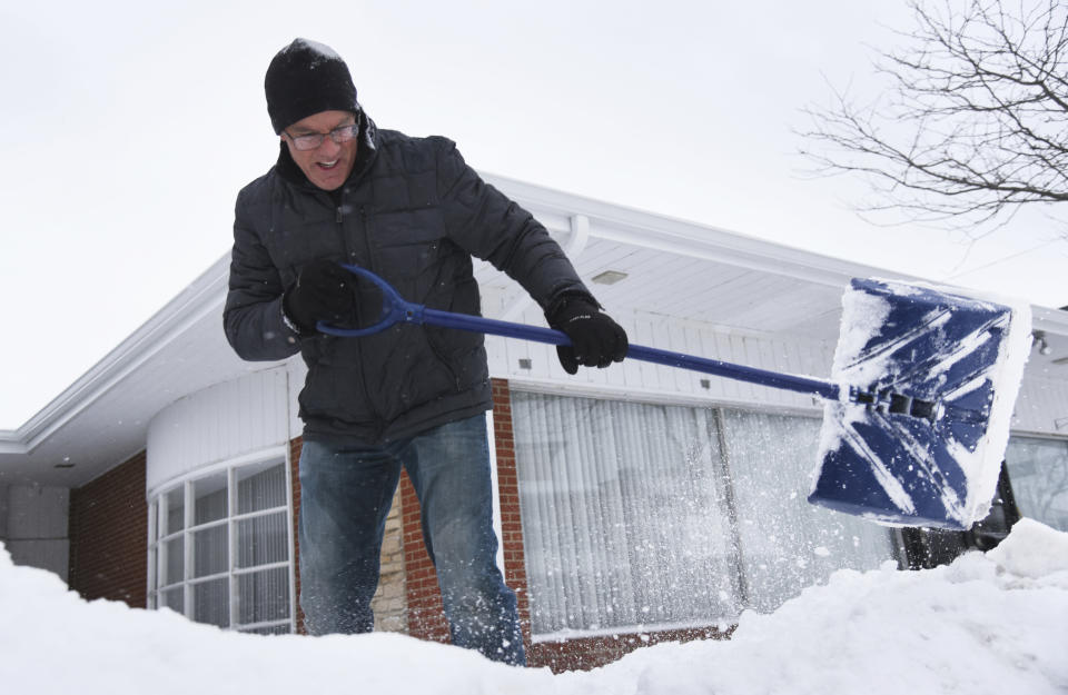 Mike Siri removes snow from in front of The Relationship Center in downtown Wauconda, Ill., Tuesday, Jan. 26, 2021. (Paul Valade/Daily Herald via AP)