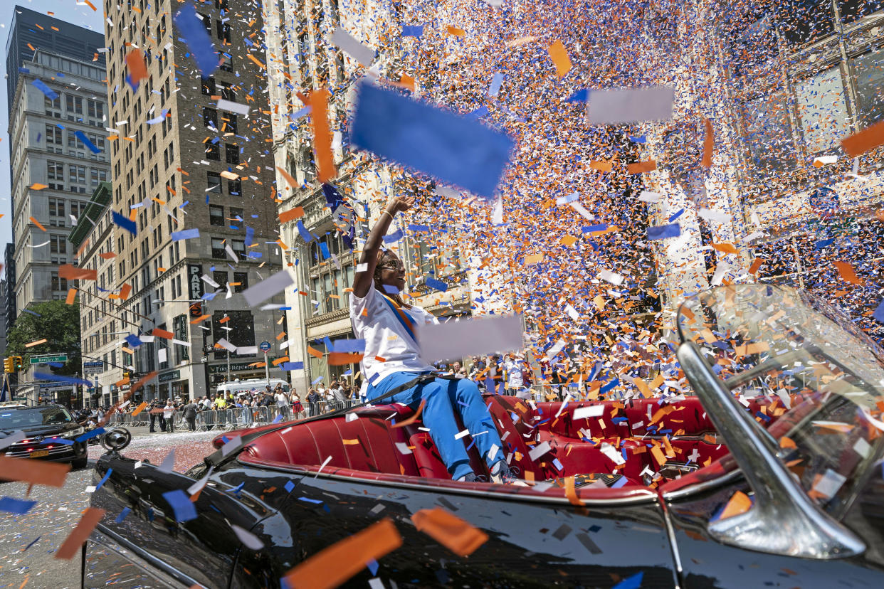 FILE - Grand marshal Sandra Lindsay, a health care worker who was the first person in the country to get a COVID-19 vaccine shot, waves to spectators as she leads marchers through the Financial District as confetti falls during a parade honoring essential workers for their efforts in getting New York City through the COVID-19 pandemic, Wednesday, July 7, 2021, in New York. (AP Photo/John Minchillo, File)