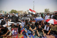 Supporters of the Shiite cleric Muqtada al-Sadr hold prayer near the parliament building in Baghdad, Iraq, Friday, Aug. 12, 2022. Al-Sadr's supporters continue their sit-in outside the parliament to demand early elections. The photo show Muqtada al-Sadr. (AP Photo/Anmar Khalil)