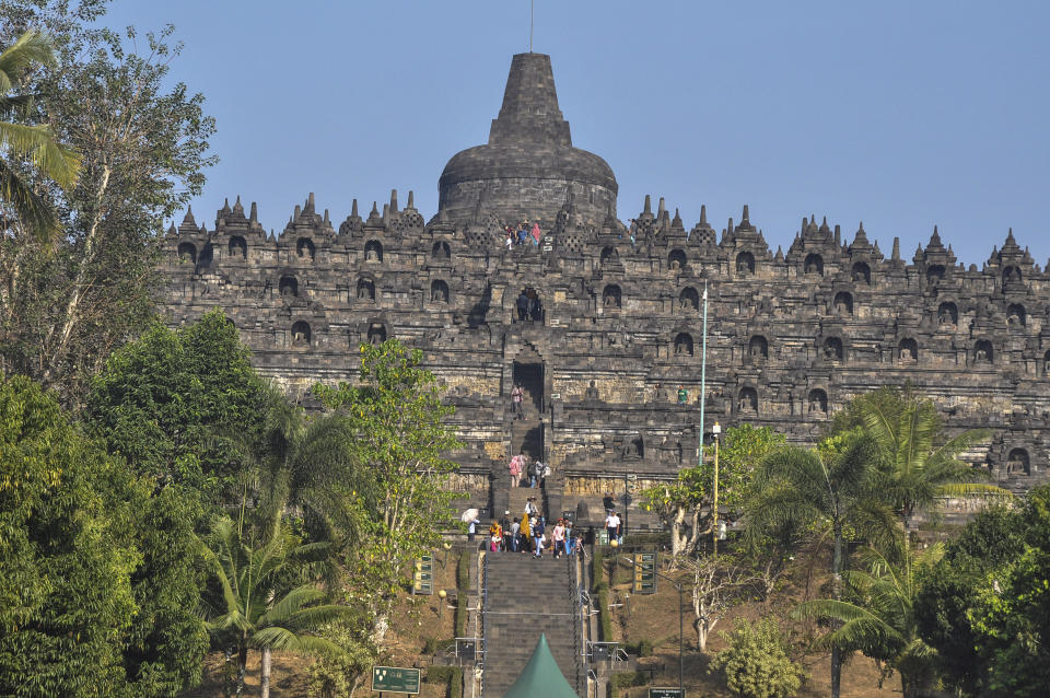 In this Monday, Aug. 12, 2019, photo, tourists visit Borobudur Temple in Magelang, Central Java, Indonesia. The Indonesian city of Yogyakarta and its hinterland are packed with tourist attractions, including Buddhist and Hindu temples of World Heritage caliber that rise like dark giants from the countryside. Yet many tourists still bypass congested Yogyakarta and head to the relaxing beaches of Bali, the archipelago's most popular destination. (AP Photo/Slamet Riyadi)