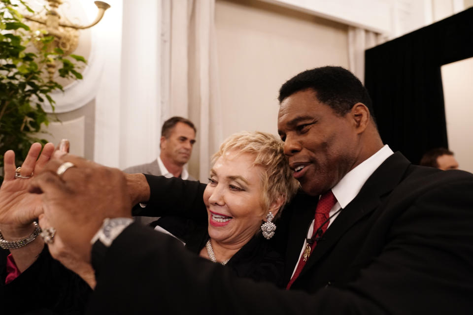 A supporter takes a photo with U.S. Senate candidate Herschel Walker during an election night watch party, Tuesday, May 24, 2022, in Atlanta. Walker won the Republican nomination for U.S. Senate in Georgia's primary election. (AP Photo/Brynn Anderson)