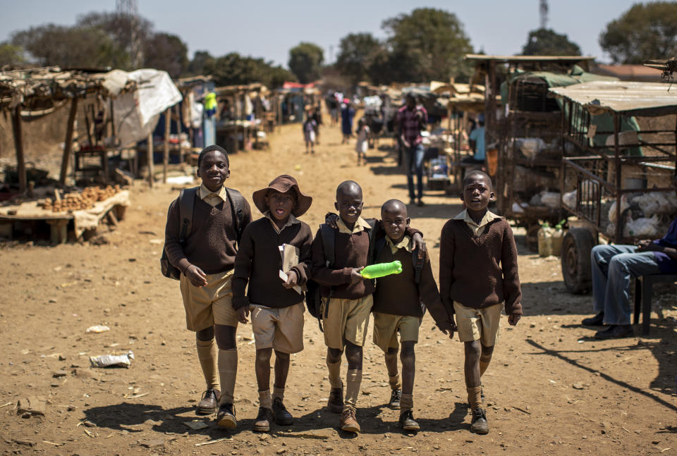 Schoolboys walk back home on the first day of the school term, in Kuwadzana, on the outskirts of the capital Harare, in Zimbabwe Tuesday, Sept. 10, 2019. Former president Robert Mugabe, who enjoyed strong backing from Zimbabwe's people after taking over in 1980 but whose support waned following decades of repression, economic mismanagement and allegations of election-rigging, is expected to be buried on Sunday, state media reported. (AP Photo/Ben Curtis)