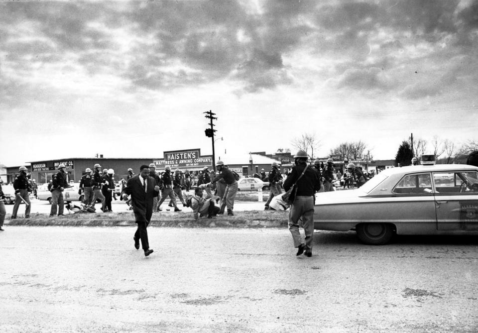 On March 7, 1965, state troopers beat hundreds of protesters crossing the Edmund Pettus Bridge in Selma, Alabama. This would be known as Bloody Sunday. Lewis is at the center of the photo, being pushed to the ground by police.