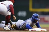 Kansas City Royals' Kyle Isbel, right, dives safely back to first base as Arizona Diamondbacks first baseman Christian Walker, left, applies a late tag during the first inning of a baseball game Monday, May 23, 2022, in Phoenix. (AP Photo/Ross D. Franklin)