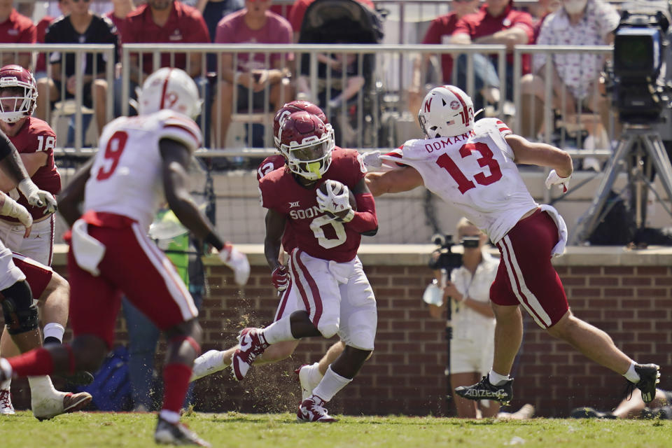 Oklahoma running back Eric Gray (0) carries past Nebraska defenders Marquel Dismuke (9) and JoJo Domann (13) in the second half of an NCAA college football game, Saturday, Sept. 18, 2021, in Norman, Okla. (AP Photo/Sue Ogrocki)