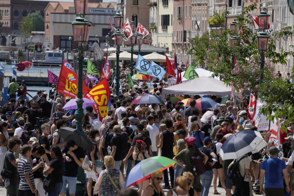 Demonstrators wave their flags as they start a protest against the G20 Economy and Finance ministers and Central bank governors' meeting in Venice, Italy, Saturday, July 10, 2021. (AP Photo/Luca Bruno)