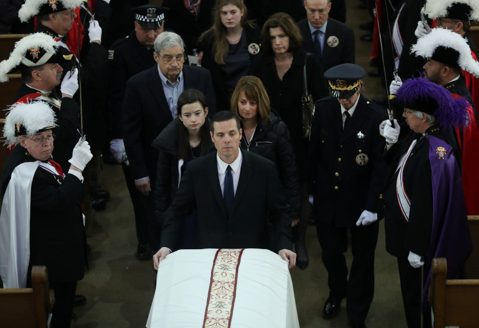 Grace Bauer, 13, and her mother, Erin Bauer, follow behind the casket of their father and husband, Chicago police Cmdr. Paul Bauer, during the recessional of his funeral mass at Nativity of Our Lord Roman Catholic Church on February 17, 2018 in Chicago, Illinois. Bauer was shot to death earlier in the week while confronting a suspect. (Photo by John J. Kim - Pool/Getty Images)