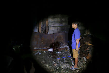 A boy arrives at the spot where his father was killed in what police said was a drug buy-bust operation in Manila, Philippines early October 18, 2016. Another person was killed in the same operation, according to police. REUTERS/Damir Sagolj