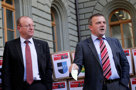 Walter Wobmann (R), National Councillor and Co-President committee for "Yes to a Mask Ban" (Ja zum Verhuellungsverbot), speaks next to Jean-Luc Addor, National Councillor, in front of boxes containing more than 100,000 signatures collected that are required to put the proposal of a ban on facial coverings worn by some Muslim women to a national vote, at the Federal Chancellery in Bern, Switzerland September 15, 2017. REUTERS/Moritz Hager