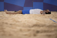 Viacheslav Krasilnikov, of the Russian Olympic Committee, lays on the sand after winning a men's beach volleyball semifinal match against Qatar at the 2020 Summer Olympics, Thursday, Aug. 5, 2021, in Tokyo, Japan. (AP Photo/Felipe Dana)