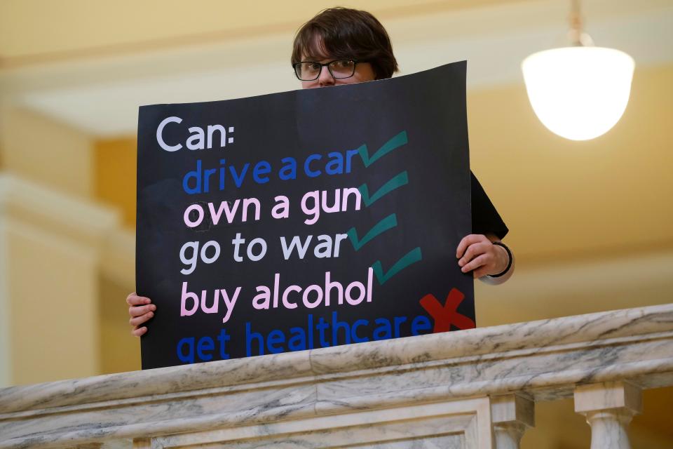 People hold signs at a trans support rally before the start of the Legislature and Gov. Kevin Stitt's State of the State speech to the joint session on Monday.