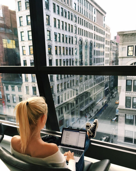 Catching up on emails with a view of Soho from her NYC apartment.