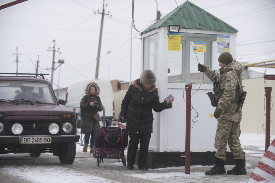 People walk to cross the border from Russia to the Ukrainian side of the Ukraine - Russia border in Milove town, eastern Ukraine, Sunday, Dec. 2, 2018. On a map, Chertkovo and Milove are one village, crossed by Friendship of Peoples Street which got its name under the Soviet Union and on the streets in both places, people speak a mix of Russian and Ukrainian without turning choice of language into a political statement. (AP Photo/Evgeniy Maloletka)