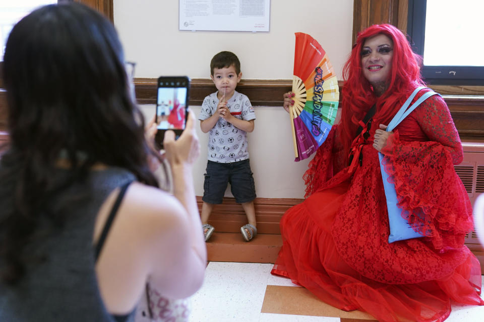 A drag queen who goes by the name Flame poses for a picture with Thomas Delattre, 2, during a Drag Story Hour at a public library in New York, Friday, June 17, 2022. (AP Photo/Seth Wenig)