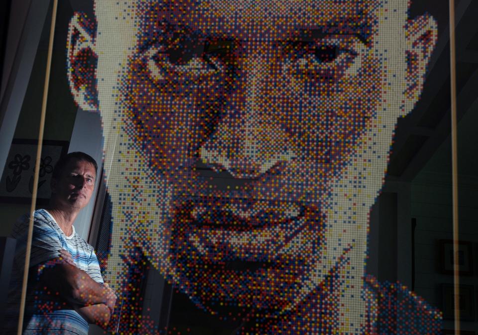 John Darovitz is reflected in his pointillist art of a likeness of Kobe Bryant from his home in Daytona Beach, Monday, May 6, 2024.