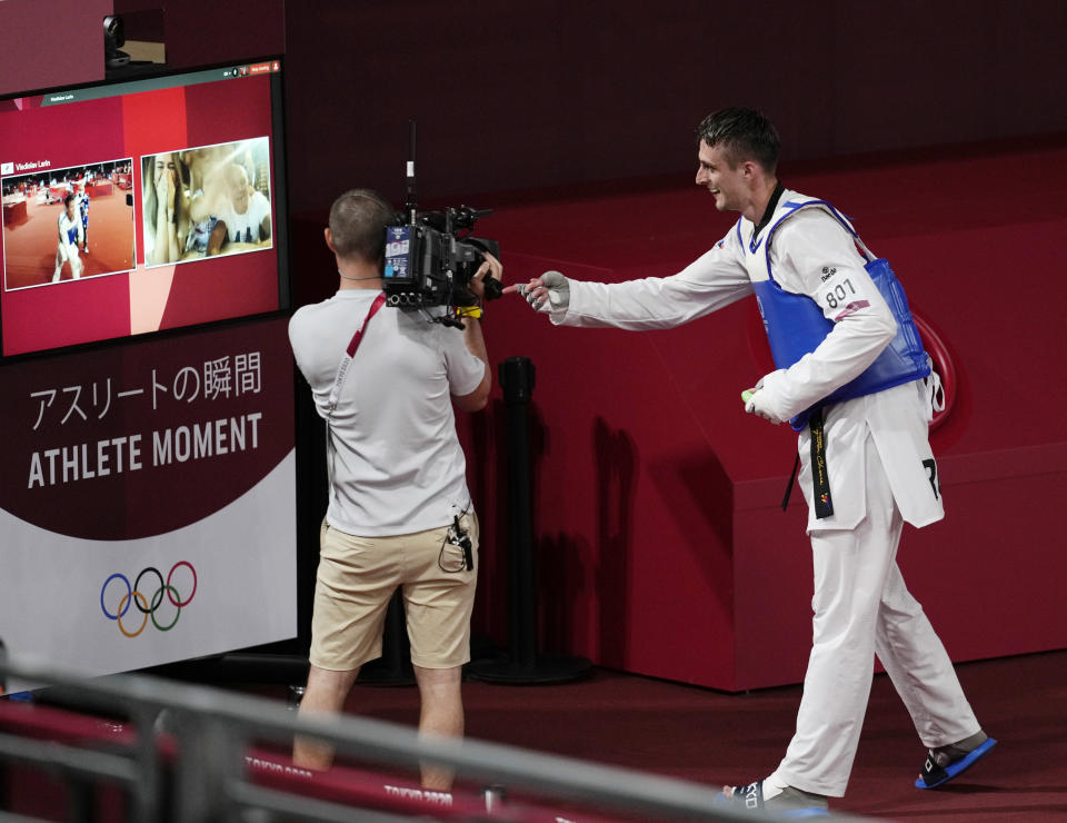 Vladislav Larin of the Russian Olympic Committee celebrates with his family via a video link after winning a gold medal for taekwondo men's 80kg match at the 2020 Summer Olympics, Tuesday, July 27, 2021, in Tokyo, Japan. (AP Photo/Themba Hadebe)