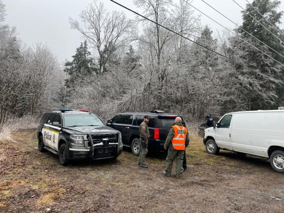 Quebec provincial police search the area near where the body of a man was found, just east of Roxham Road, a well-travelled unofficial border crossing for asylum seekers hoping to cross into Canada, on Jan. 5, 2022. (Jacaudrey Charbonneau/Radio-Canada - image credit)