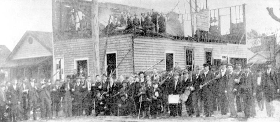 Members of a white vigilante mob pose for a photograph after burning Wilmington, N.C.’s black-readership newspaper, The Daily Record Nov. 10, 1898.