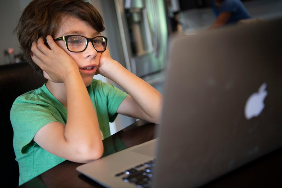 Glendale Elementary first grader Hawkes Powell tries to pay attention to his virtual class on the first day of school Aug. 4 in Nashville, Tenn.