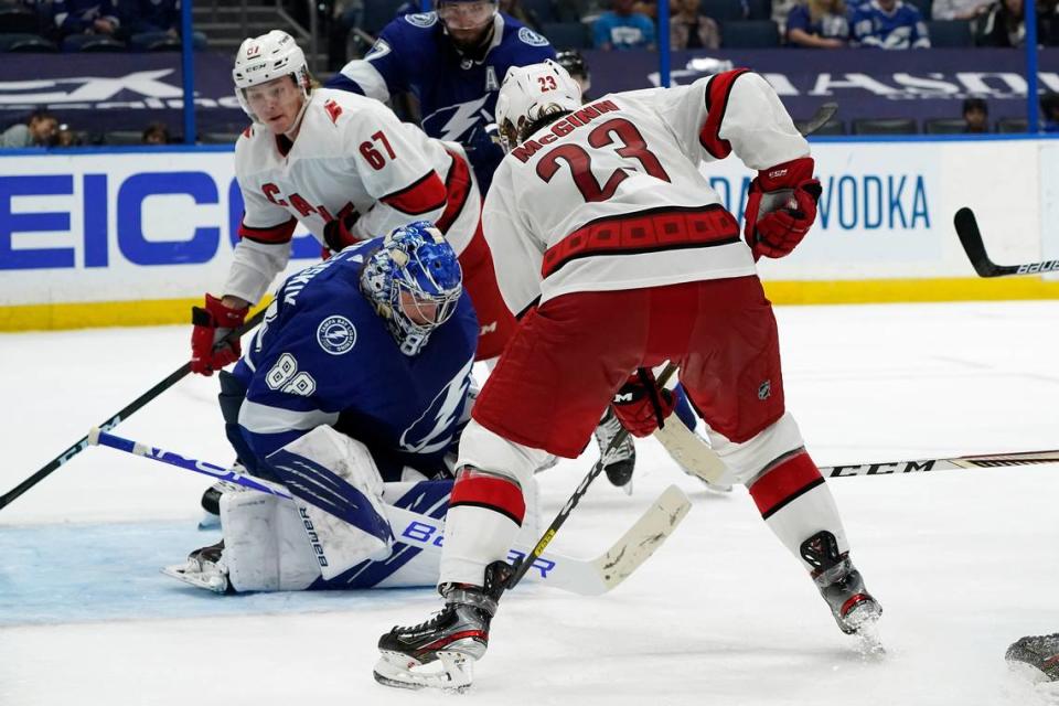 Tampa Bay Lightning goaltender Andrei Vasilevskiy (88)makes a save as Carolina Hurricanes left wing Brock McGinn (23) and center Morgan Geekie (67) look for a rebound during the third period in Game 4 Saturday, June 5, 2021, in Tampa, Fla. (AP Photo/Chris O’Meara)