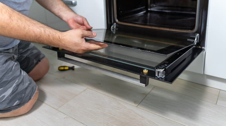 Man removing glass from oven door