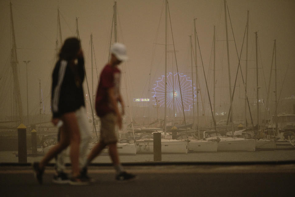 Yachts and boats sit moored in a cloud of red dust in Santa Cruz de Tenerife, Spain, Sunday, Feb. 23, 2020. Flights leaving Tenerife have been affected after storms of red sand from Africa's Saharan desert hit the Canary Islands. (AP Photo/Andres Gutierrez)