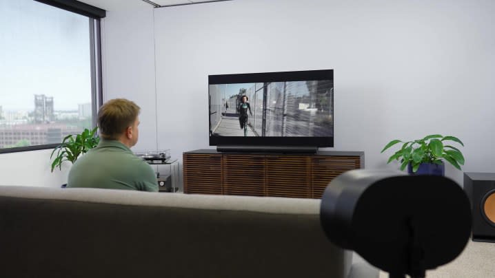 A man watches a movie in a studio with a Sonos Era 300 in a surround sound setup.