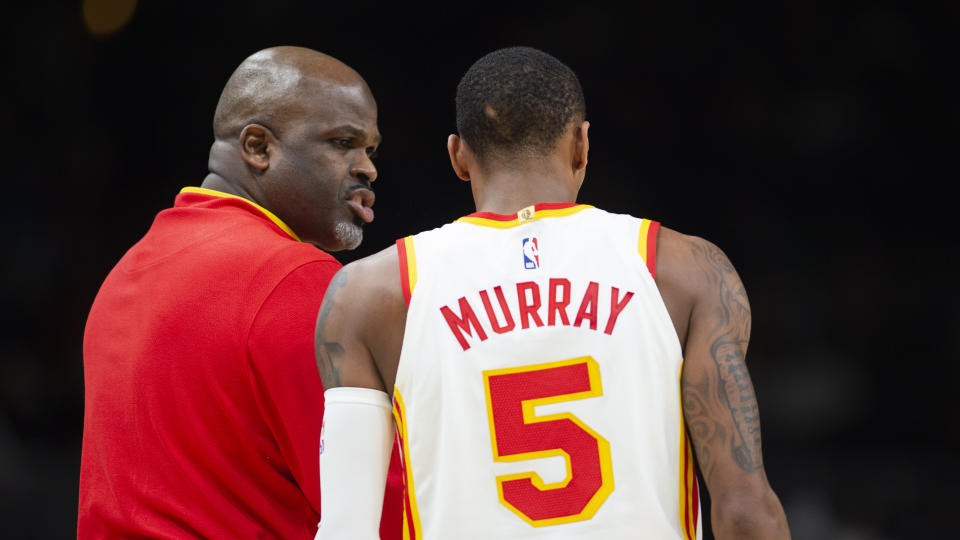 Atlanta Hawks head coach Nate McMillan, left, speaks to guard Dejounte Murray (5) during the second half of an NBA basketball game against the Denver Nuggets, Friday, Dec. 2, 2022, in Atlanta. (AP Photo/Hakim Wright Sr.)