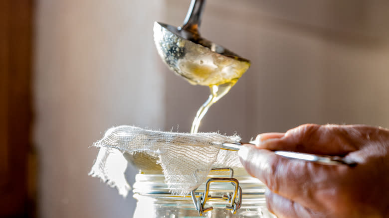 Butter being strained through cheesecloth