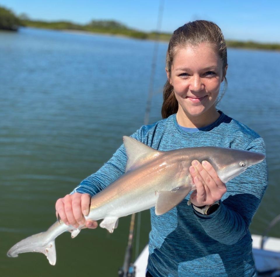 Maddie Schense with a small sandbar shark she caught on Capt. Jeff Patterson's Pole Dancer charter boat.