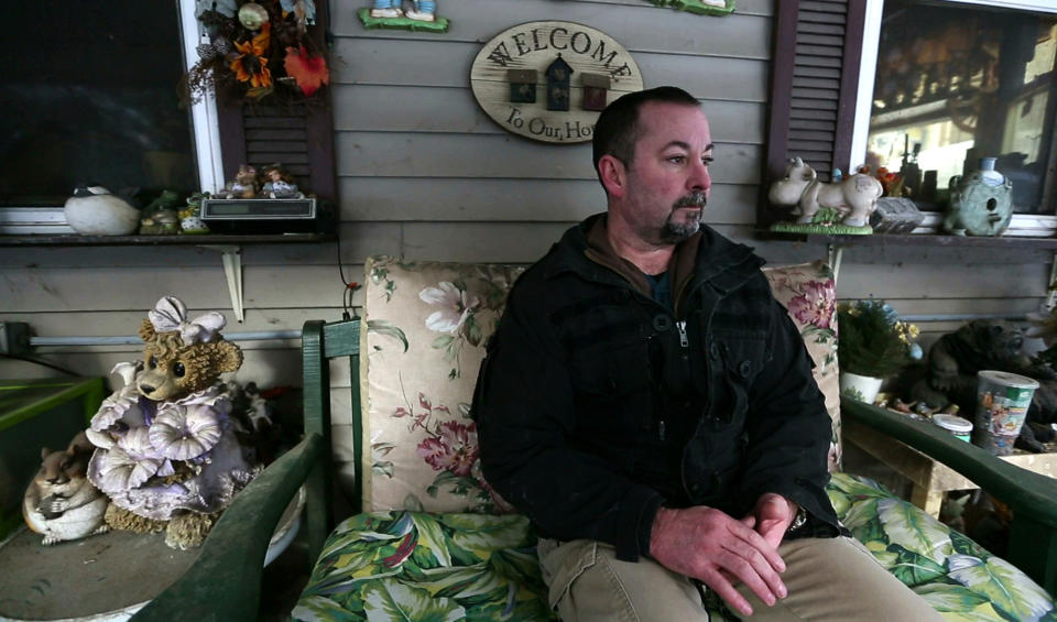 In this Thursday, March 7, 2019 photo, former SWAT officer Al Joyce sits on the porch at his mother's home in Otisfield, Maine. Joyce left his job in law enforcement in Jefferson County, Colorado, after a school shooting and now works as a cashier. Joyce was part of the team that in 2006 stormed a classroom in Platte Canyon High School in the town of Bailey, southwest of Denver and saw the aftermath of a shooting. It wasn't long before the nightmares began and he started drinking heavily to avoid them. He ended up leaving the SWAT team, divorcing his wife and withdrawing from the world. "I wanted to just shut down, turn off," he said. "It didn't work out so well."(AP Photo/Robert F. Bukaty)