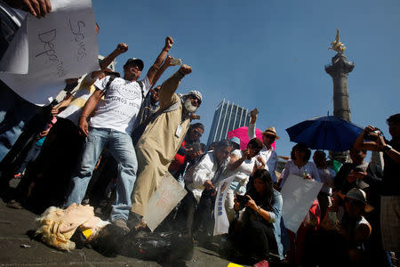 Demonstrators step on a pinata of U.S. President Donald Trump during a protest against Trump's proposed border wall and to call for unity, in Mexico City, Mexico, February 12, 2017. REUTERS/Jose Luis Gonzalez