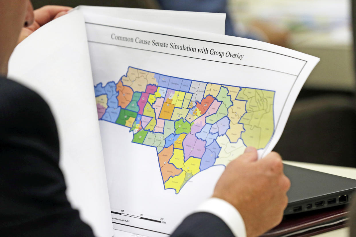 A lawmaker studies a district map during a joint select committee meeting on redistricting (Gerry Broome / AP file)