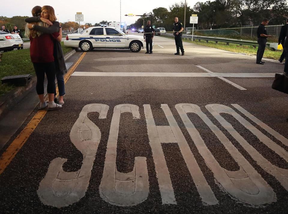 PHOTO: Kristi Gilroy (R), hugs a young woman at a police check point near the Marjory Stoneman Douglas High School where 17 people were killed by a gunman yesterday, Feb. 15, 2018, in Parkland, Fla. (Mark Wilson/Getty Images)