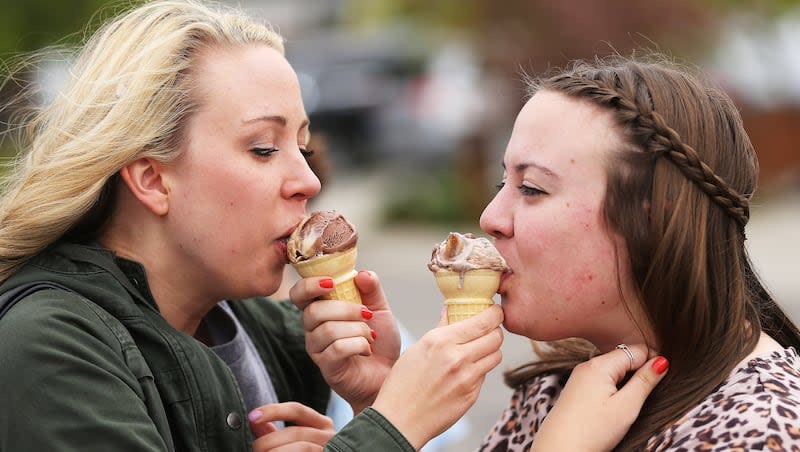 Sarah and Emily Topham taste each other's free ice cream cones in Orem April 14, 2015. Each year, Ben & Jerry's hosts Free Cone Day.