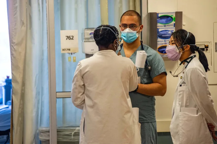 Medical workers confer in the ICU ward