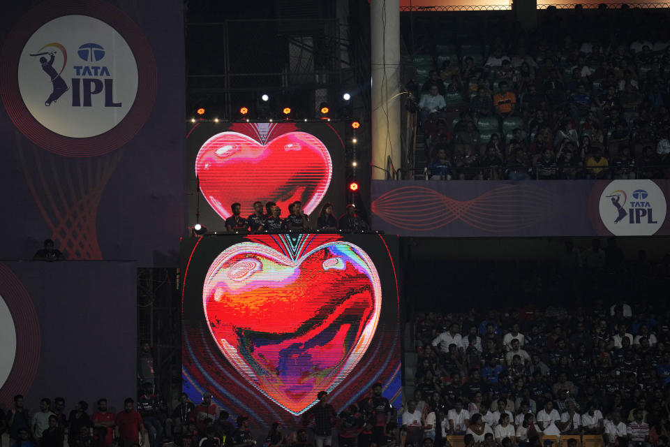 Heart shaped pictures are displayed on an electronic screen as spectators wait for the third umpire's decision for a possible run-out during the Indian Premier League cricket match between Royal Challengers Bangalore and Mumbai Indians in Bengaluru, India, Sunday, April 2, 2023. (AP Photo/Aijaz Rahi)
