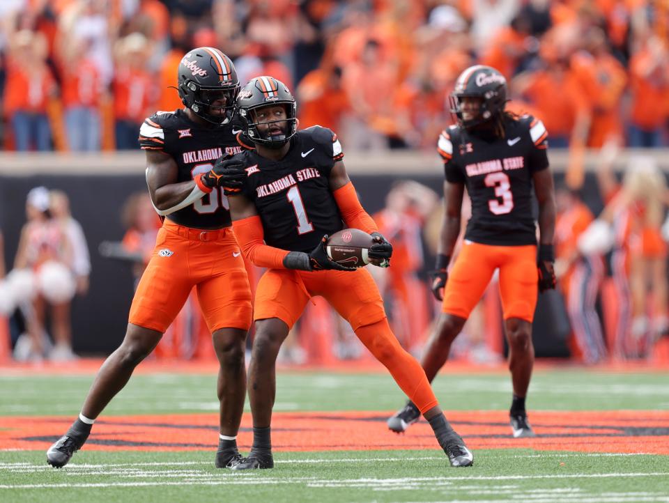 Oklahoma State's Xavier Benson (1) and Collin Oliver (30) celebrate a fumble recovery in the first half during a Bedlam college football game between the Oklahoma State University Cowboys (OSU) and the University of Oklahoma Sooners (OU) at Boone Pickens Stadium in Stillwater, Okla., Saturday, Nov. 4, 2023.