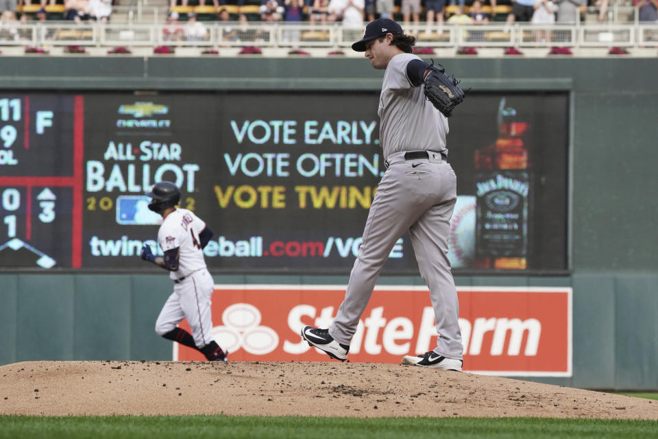 New York Yankees pitcher Gerrit Cole, right, reacts after giving up a solo home run to Minnesota Twins' Carlos Correa, left, during the first inning of a baseball game Thursday, June 9, 2022, in Minneapolis. It was the third home run in a row that Cole gave up in the inning. (AP Photo/Jim Mone)