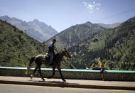 A man rides a horse against the backdrop of the Tien Shan mountains near the Medeu skating oval in Almaty, Kazakhstan, July 26, 2015. REUTERS/Shamil Zhumatov