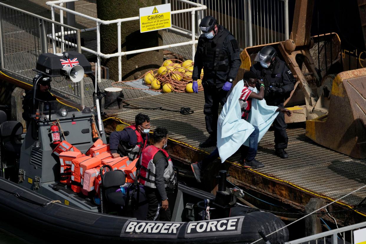 Men thought to be migrants who undertook the crossing from France in small boats and were picked up in the Channel, are disembarked from a small transfer boat from a larger British border force vessel that didn't come into the port, in Dover, south east England, Friday, June 17, 2022. The British government vowed Wednesday to organize more flights to deport asylum-seekers from around the world to Rwanda, after a last-minute court judgment grounded the first plane due to take off under the contentious policy. (AP Photo/Matt Dunham)
