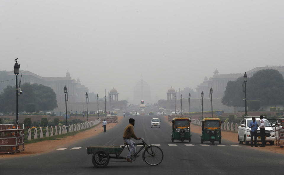 A cyclist paddles his cart as the city envelops in smog in New Delhi, India, Thursday, Nov. 7, 2019. The air quality index stood at 273 on Thursday in the capital after authorities declared a health emergency last weekend when the index crossed 500 — 10 times the level considered healthy by WHO standards. (AP Photo/Manish Swarup)