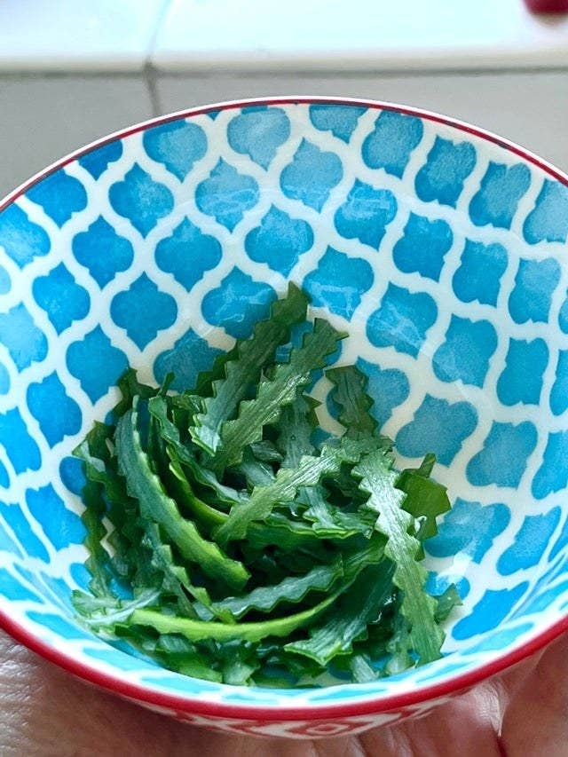 Sliced green onion with crimped edges.